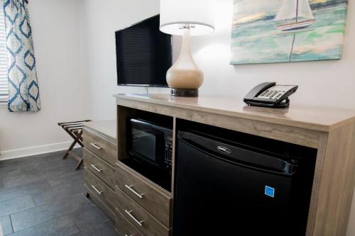 ein Schreibtisch mit einer Mikrowelle, einer Lampe und einem Telefon in der Unterkunft Beaches and Waves Resort View 3rd Floor in Pawleys Island