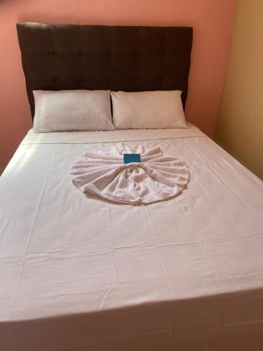 a bed with a white bedspread with a ribbon on it at LM Flats - Beach Park Porto das Dunas in Aquiraz