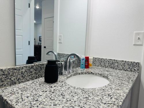 a bathroom counter with a sink and a mirror at Modern 3BR-Ample Home near Walmart HQ & Downtown in Bentonville