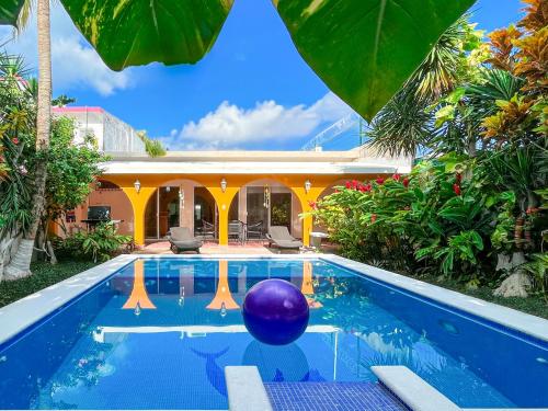 a pool with a purple ball in front of a house at Troy's House in Cozumel