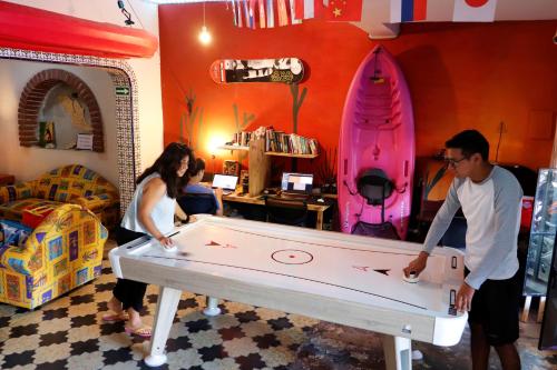 a man and a woman playing with a pool table at Sunset Hostel - Centro - in La Paz