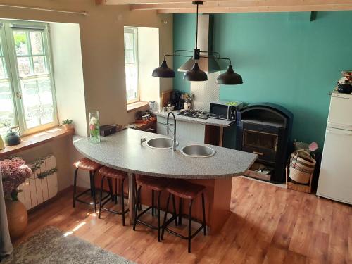 une cuisine avec un grand îlot et des tabourets de bar dans l'établissement Le Triskelium, à Landebaëron