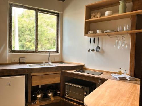 een keuken met een spoelbak en een raam bij Refúgio perto do mar em Mariscal 02 in Bombinhas