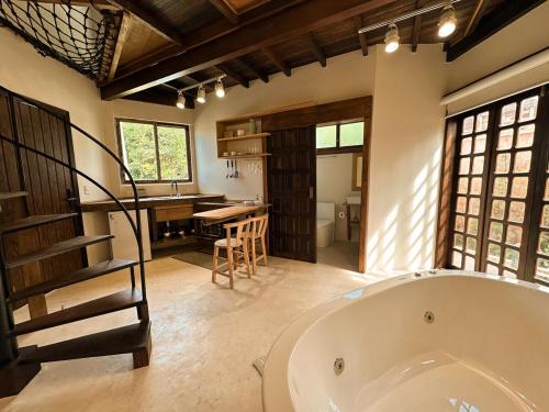 een grote badkamer met een bad en een trap erin bij Refúgio perto do mar em Mariscal 02 in Bombinhas