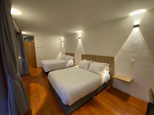 a bedroom with two beds with white sheets at Apartaestudio comodo y central S2 - WiFi in Pasto