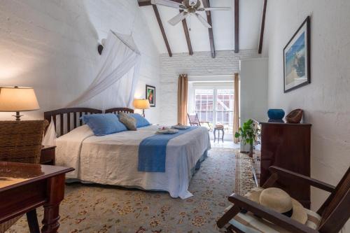 a bedroom with a bed with blue pillows at Admiral's Inn and Gunpowder Suites in English Harbour Town