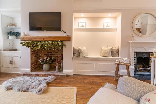 a living room with a fireplace and a tv at The Railway Cottage in Rothley