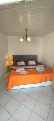 a bedroom with a large bed with an orange blanket at Casa do Carvoeiro in Fundão