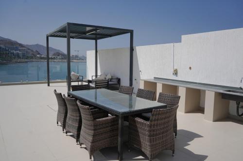 a glass table and chairs on a patio at Al Dana H2O Luxury Villa in Fujairah
