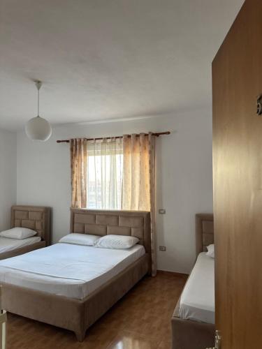 a bedroom with two beds and a window at GuestHouse Cami in Durrës