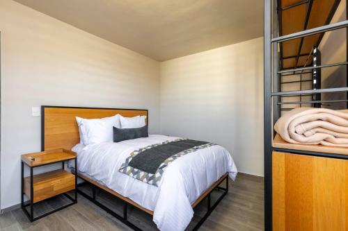 a small bedroom with a bed and a night stand at Lofts By Verticca in Santa Cruz Tecamac