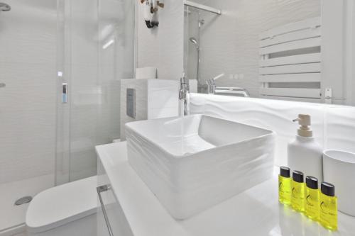 une salle de bain blanche avec un lavabo et des toilettes dans l'établissement Le Croisette - Terrace - AC - Hypercentre - WIFI, à Cannes