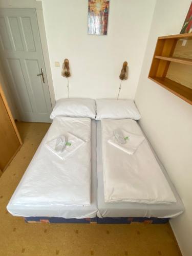 a bed in a room with white sheets at Vila Lenka in Pěnčín