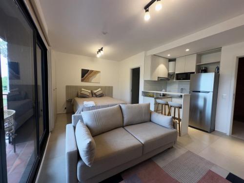 a living room with a couch and a bed and a kitchen at Departamento en Luque cerca a Asunción 119 in Caña de Castilla