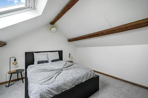 une chambre avec un lit noir et blanc et une fenêtre dans l'établissement L'Écrin Parisien - Proche Paris - 10 pers, à Noisy-le-Grand