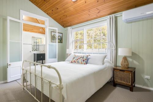 a bedroom with a white bed and a window at Historic Huntingdon House in Wauchope