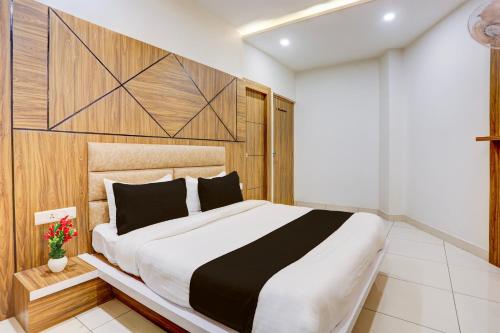 a bedroom with a large bed with a wooden headboard at Super Townhouse Model Town Rohtak Formerly Hotel Tathastu in Rohtak
