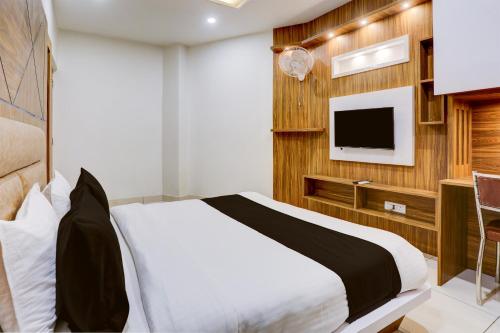 a bedroom with a bed and a tv on a wall at Super Townhouse Model Town Rohtak Formerly Hotel Tathastu in Rohtak