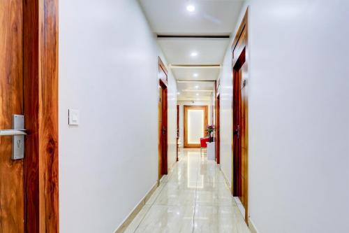 a hallway with white walls and a white tile floor at Super Townhouse Model Town Rohtak Formerly Hotel Tathastu in Rohtak