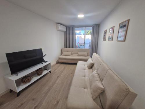 a living room with a couch and a flat screen tv at Funcional, céntrico y cómodo in Montevideo