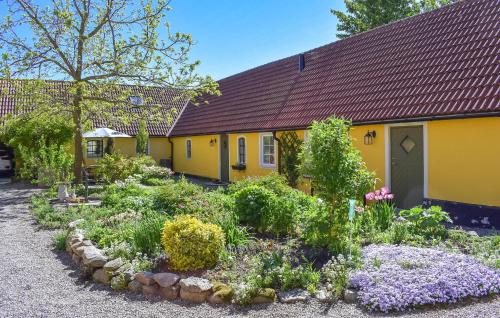 una casa amarilla con un jardín delante de ella en Nice Home In Sjöbo With Wifi, en Sjöbo