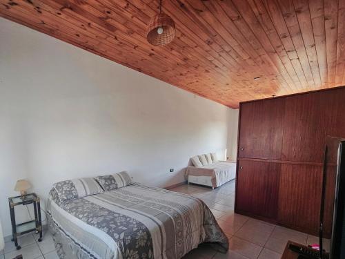 a bedroom with a bed and a wooden ceiling at Loft La Mística in San Antonio de Areco