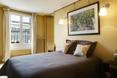une chambre avec un grand lit et une fenêtre dans l'établissement Paris Louvre Elegant residence, à Paris