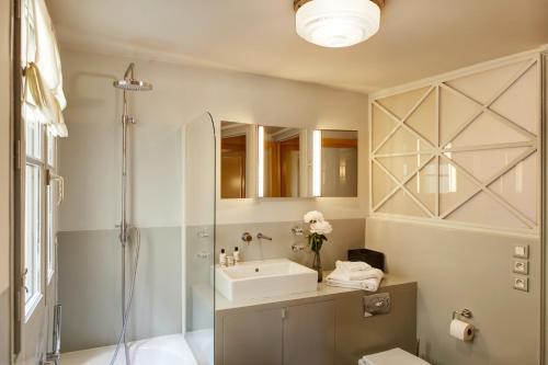 une salle de bain avec un lavabo et une douche dans l'établissement Paris Louvre Elegant residence, à Paris