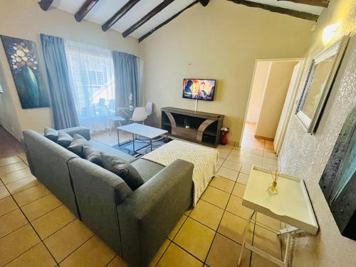 ein Wohnzimmer mit Couch und Kamin in der Unterkunft Exquisite cottage in Doringkloof in Centurion