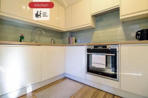 a kitchen with white cabinets and a sink and an oven at Two Bedroom Apartment By Littlepiggyrentals Short Lets & Serviced Accommodation Hatfield With WiFi & Free Parking in Hatfield