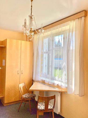 a kitchen with a table and two chairs and a window at Vila Lenka in Pěnčín