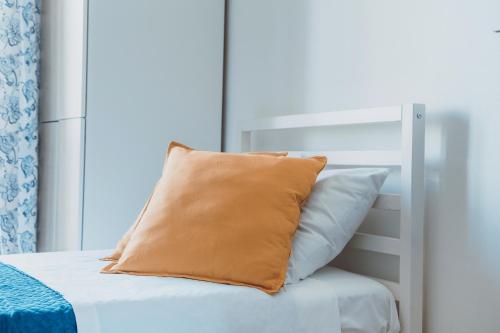 an orange pillow sitting on top of a bed at Manfredi Apartments in Torre Annunziata