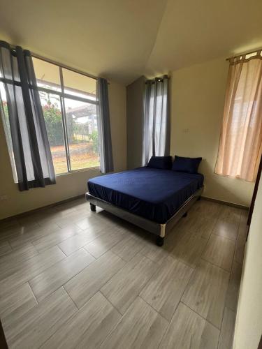a bedroom with a bed and a wooden floor at Casa Vacacional PVM in Puerto Quito