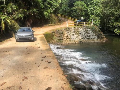 a car parked on a road next to a river at Casa Vacacional PVM in Puerto Quito