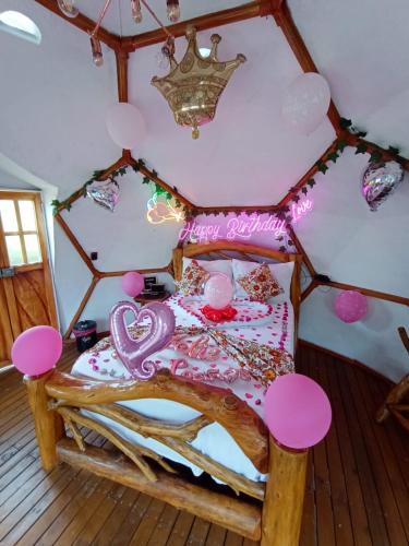 a room with a bed with pink decorations on it at Glamping Girardot & Hotel Puerta Del Sol Girardot in La Virginia