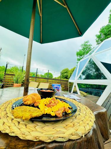 a plate of breakfast food on a table at Glamping Girardot & Hotel Puerta Del Sol Girardot in La Virginia