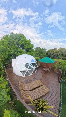 a patio with a white tent and chairs and tables at Glamping Girardot & Hotel Puerta Del Sol Girardot in La Virginia