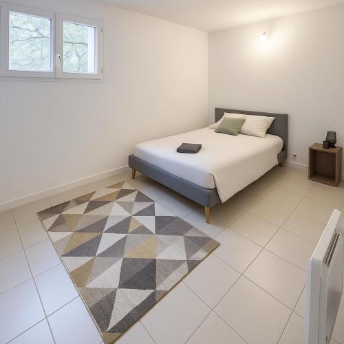 une chambre avec un lit et un tapis dans l'établissement Le petit refuge, à Malaucène