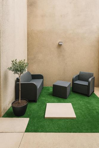 une pièce avec deux canapés et une plante en pot dans l'établissement Le petit refuge, à Malaucène