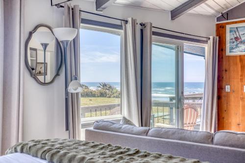 a bedroom with a couch and a large window at Moolack Shores Inn in Newport