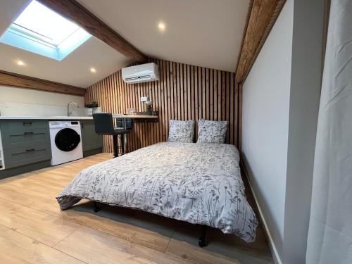 a bedroom with a bed and a kitchen at Studio au bord du canal du midi in Carcassonne