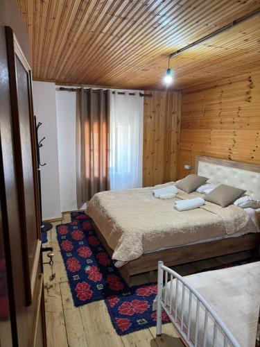 a bedroom with a large bed in a wooden room at Bujtina Carku in Theth