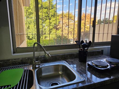 Una encimera de cocina con un fregadero y una ventana. en Habitación #2 TALPA CASA GILTOWN, en Guadalajara