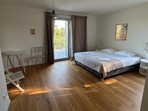 a bedroom with a bed and a sliding glass door at Supetar Cypress House - near the beach in Supetar