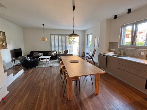cocina y sala de estar con mesa de madera en una habitación en Supetar Cypress House, en Supetar