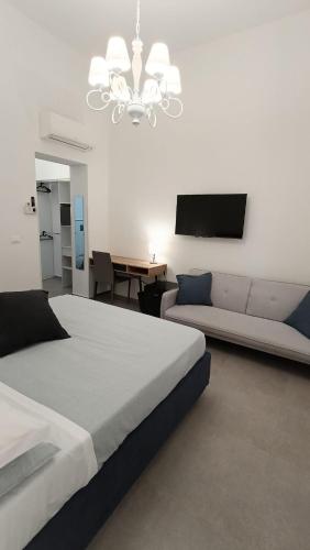 1 dormitorio con cama, sofá y lámpara de araña en Foresteria del Genio - Luxury Suites & Urban Spa, en Palermo