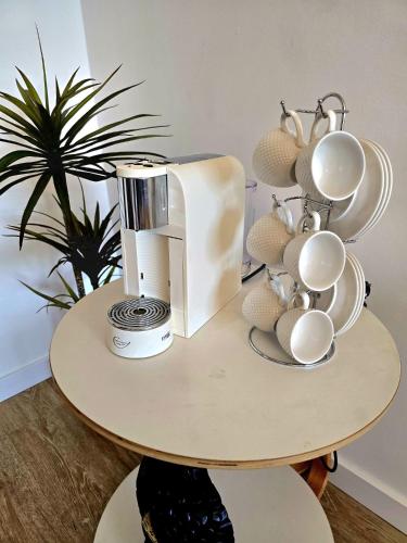 a table with a coffee maker and cups on it at Paim Lodge in Ponta Delgada