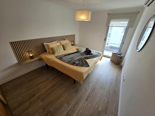 a bedroom with a large bed with a wooden floor at Paim Lodge in Ponta Delgada