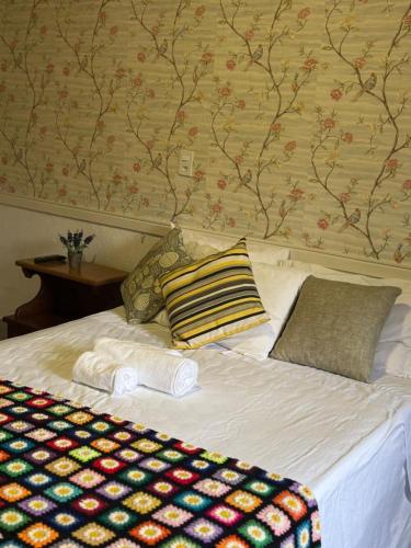 a bed with two pillows on top of it at VILA ACONCHEGO AZUL- casa 1 in Aracê