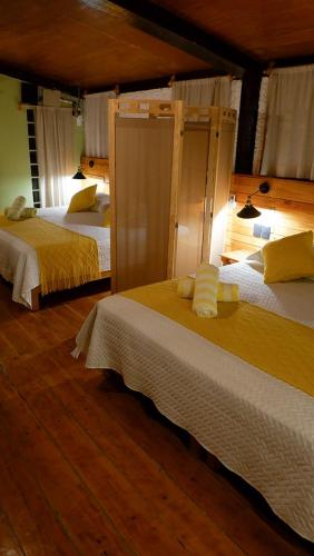 1 Schlafzimmer mit 2 Betten und gelber Bettwäsche in der Unterkunft Casa del Tatich Lodge in Leona Vicario